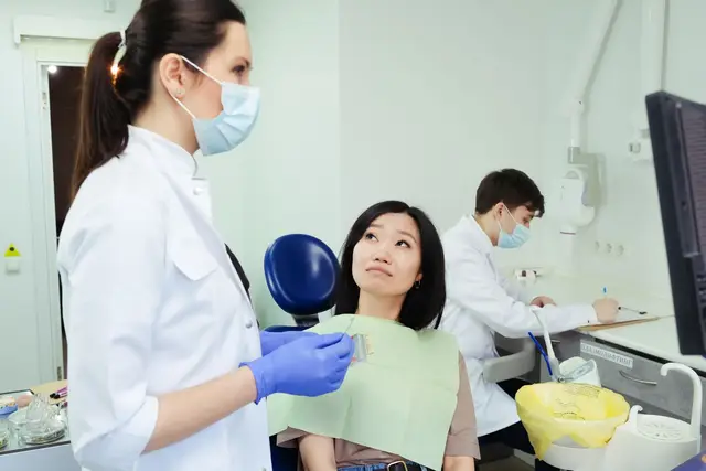 A patient in a bright dental chair talking with the dentist